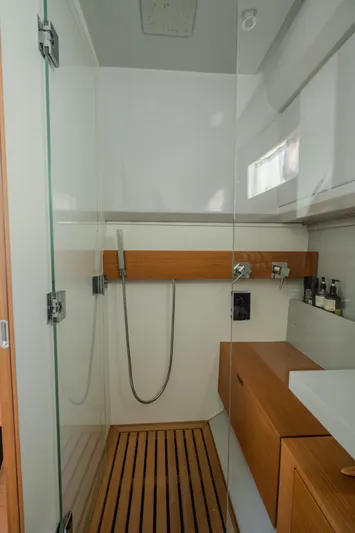  Yacht Photos Pics Modern shower area in 2019 Bluegame BG42 yacht with glass door and wooden accents.