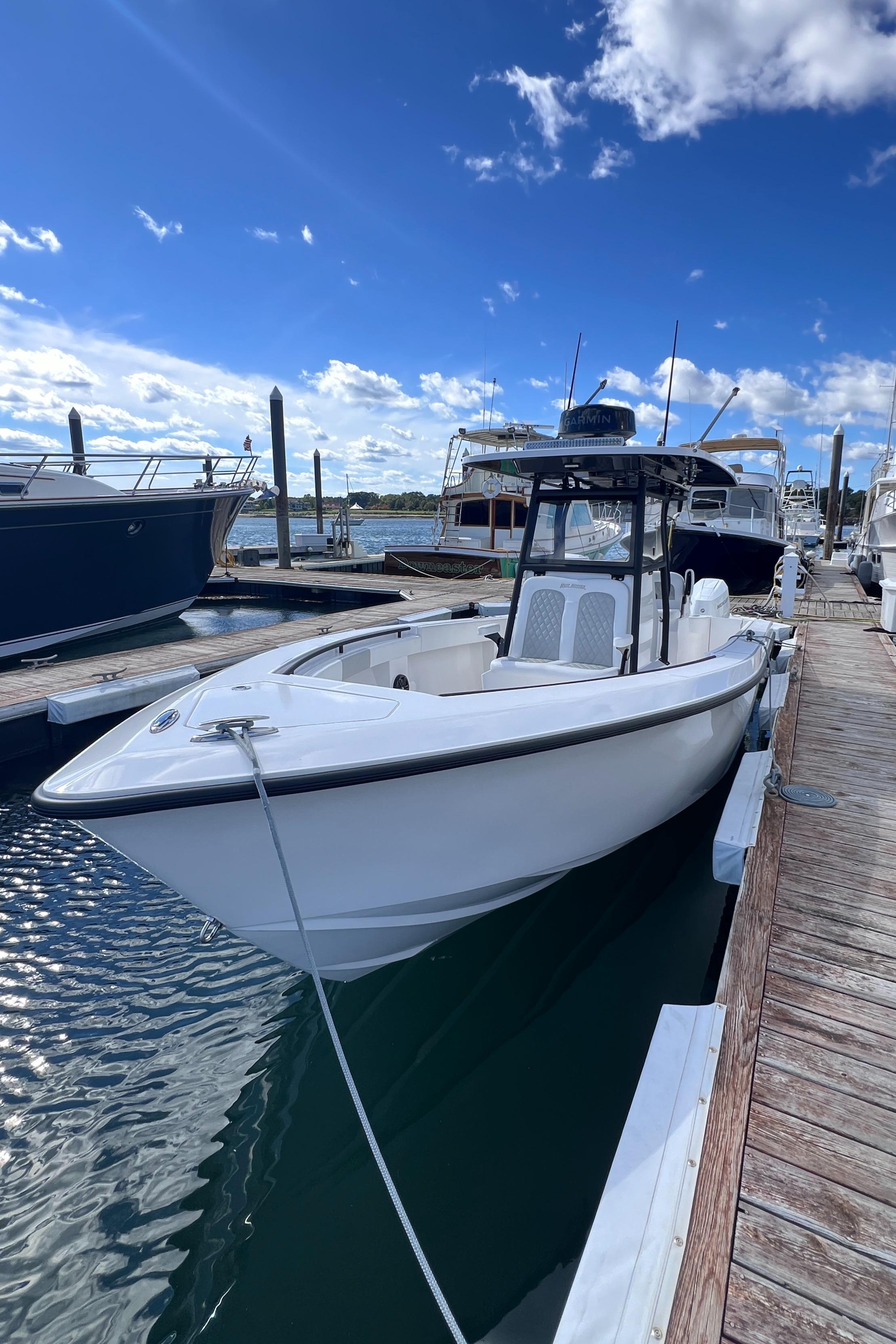 2025 Reef Runner 280 boat docked at marina under blue sky.