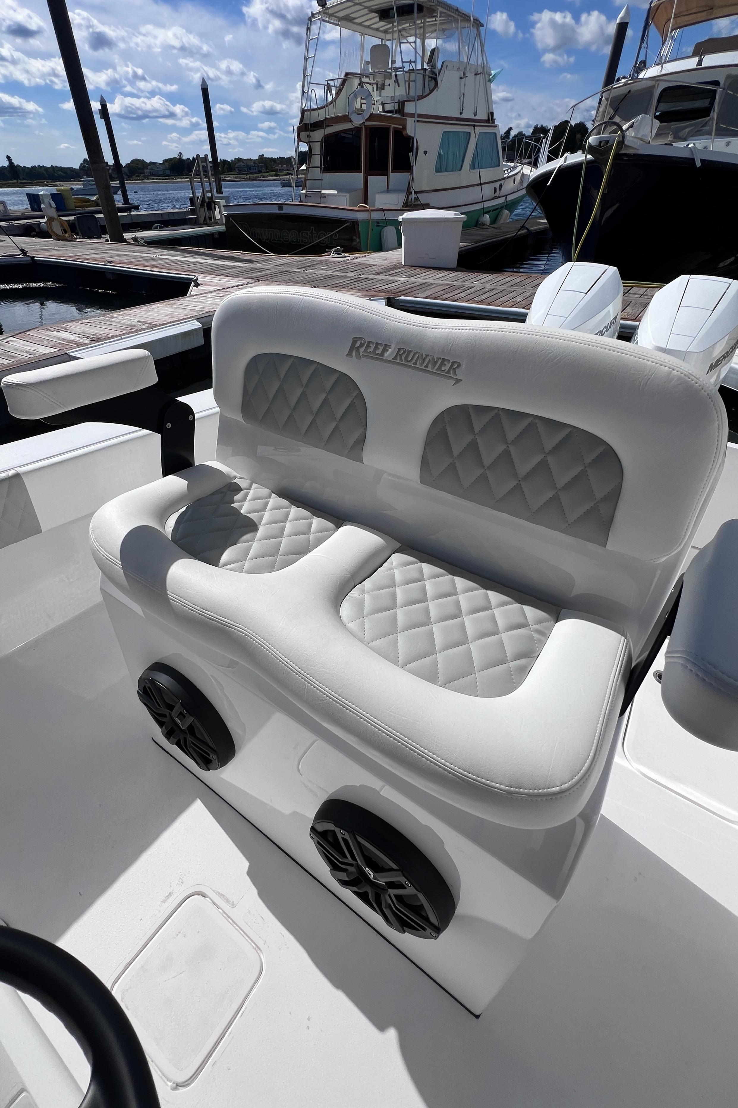 2025 Reef Runner 280 boat with luxurious white seating and quilted design at marina.