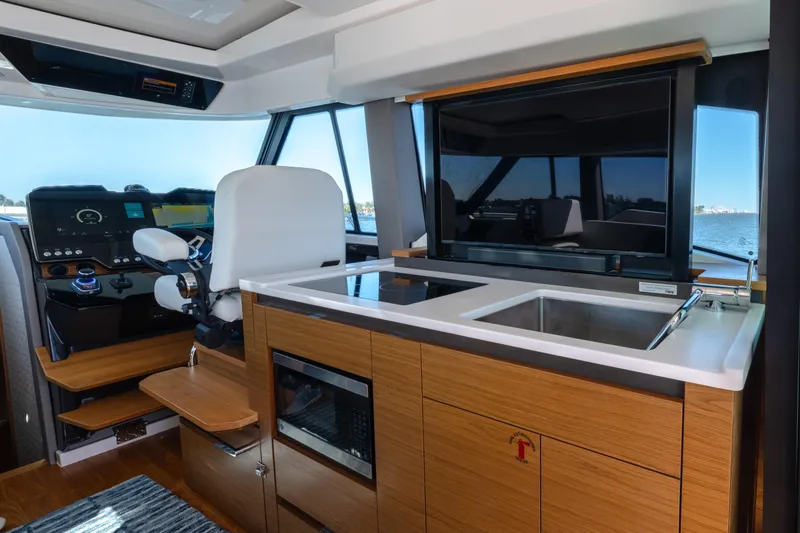 Next Level Yacht Photos Pics Interior of 2025 Tiara Yachts 43 LE, featuring helm and kitchenette with modern amenities.