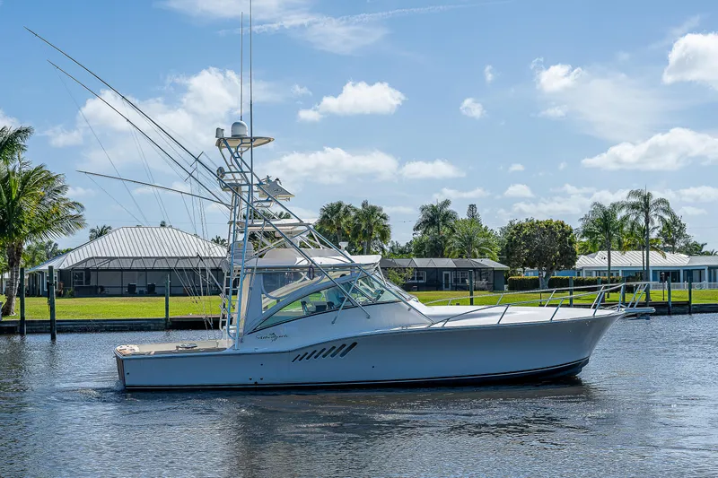 Atica Yacht Photos Pics 2005 Albemarle 410 boat cruising on a sunny day near waterfront homes.