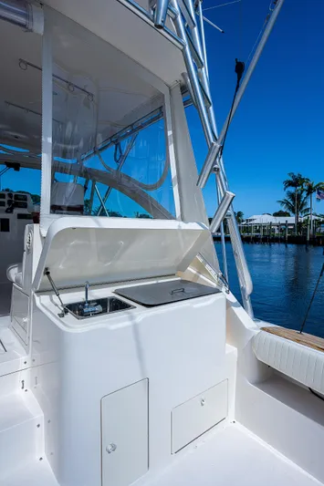 Atica Yacht Photos Pics 2005 Albemarle 410 boat with outdoor sink and storage, docked by a serene waterfront.