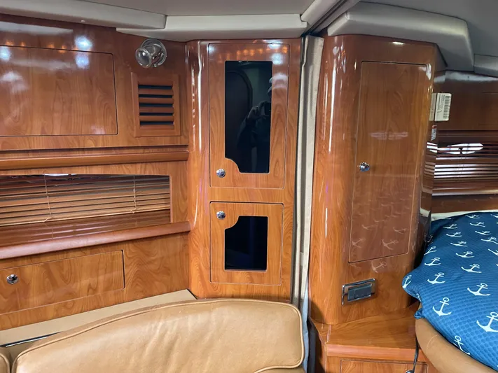  Yacht Photos Pics 2006 Four Winns 350 yacht interior with polished wood cabinetry and nautical-themed bedding.