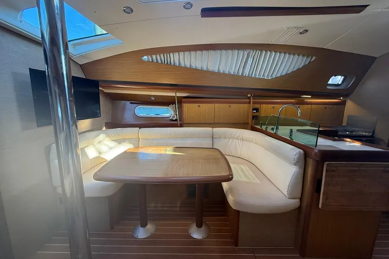 Tbd Yacht Photos Pics Luxurious interior of 2008 Jeanneau Sun Odyssey 42 DS sailboat with dining area and kitchenette.