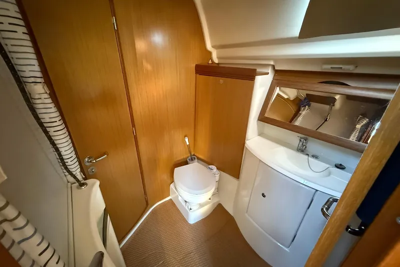 Tbd Yacht Photos Pics 2008 Jeanneau Sun Odyssey 42 DS yacht bathroom with wooden cabinetry and modern fixtures.