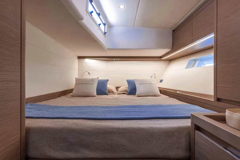  Yacht Photos Pics Luxurious cabin interior of 2026 Grand Soleil 52 Performance yacht, featuring elegant bedding and modern design.