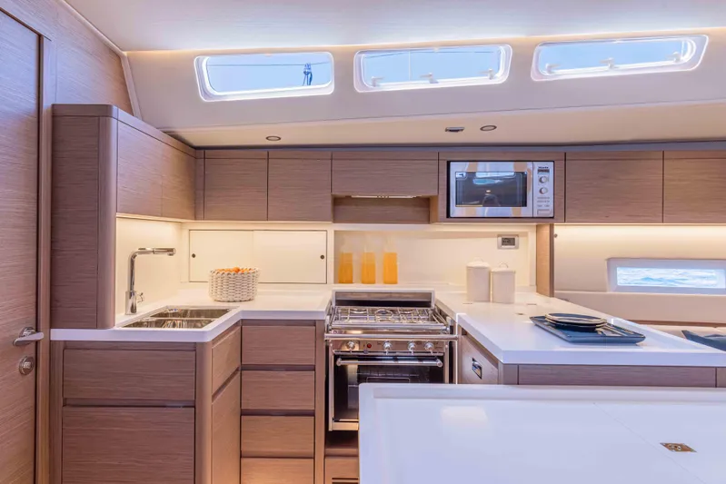  Yacht Photos Pics Modern kitchen interior of 2026 Grand Soleil 52 Performance yacht, featuring sleek cabinetry and appliances.