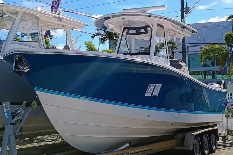  Yacht Photos Pics 2024 Regulator 31 boat on trailer, blue and white design, displayed outdoors.
