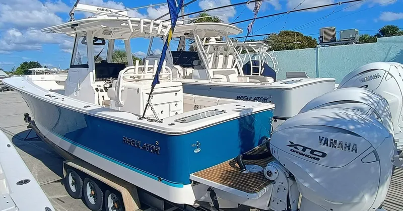  Yacht Photos Pics 2024 Regulator 31 boat with Yamaha XTO engines, docked under a clear blue sky.