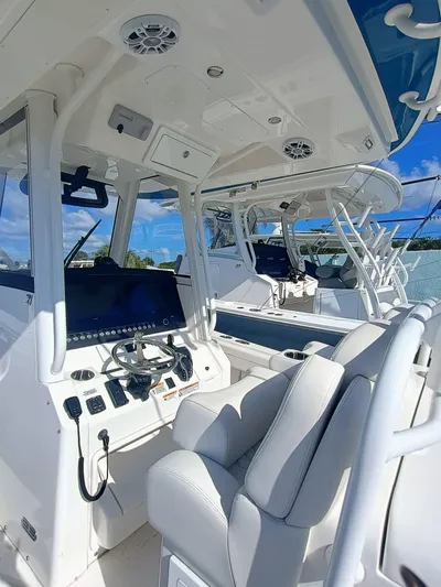  Yacht Photos Pics 2024 Regulator 31 boat interior with modern controls and seating under a clear blue sky.