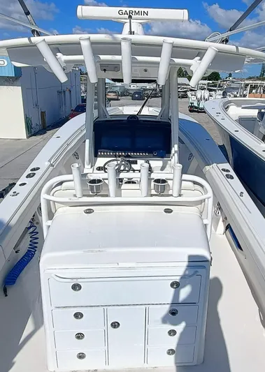  Yacht Photos Pics 2024 Regulator 31 boat cockpit with Garmin electronics and rod holders under a clear blue sky.