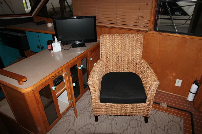 Aurora II Yacht Photos Pics Interior of 1989 Chris-Craft 480 Catalina with wicker chair and small TV.