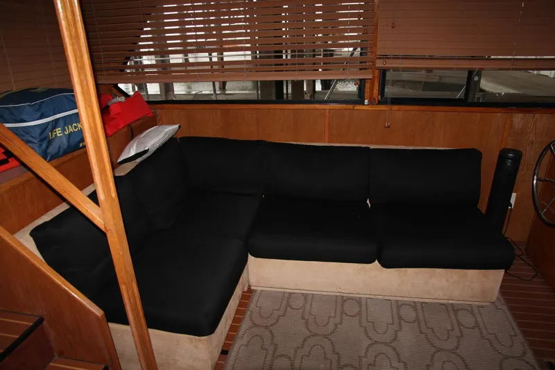 Aurora II Yacht Photos Pics Interior of 1989 Chris-Craft 480 Catalina with black sofa and wooden blinds.