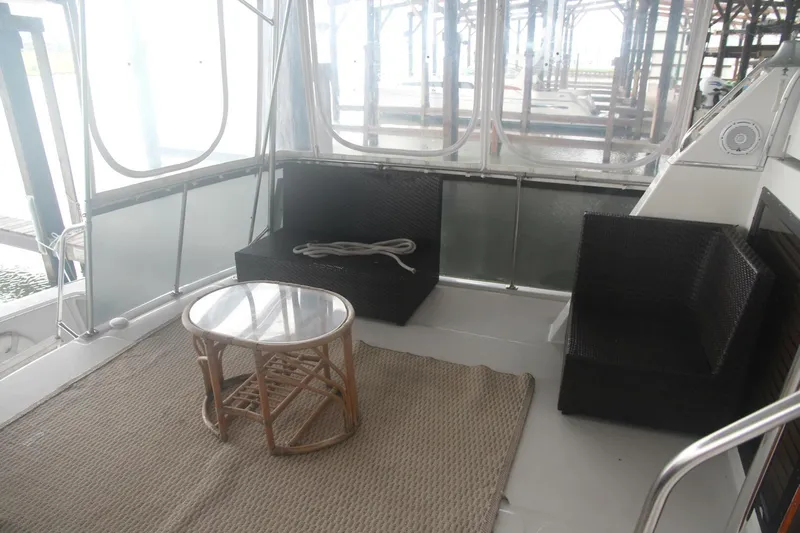 Aurora II Yacht Photos Pics 1989 Chris-Craft 480 Catalina yacht interior with wicker furniture and glass table.