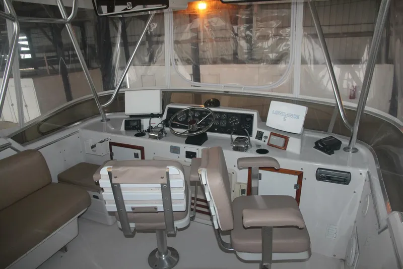 Aurora II Yacht Photos Pics 1989 Chris-Craft 480 Catalina boat cockpit with steering wheel and navigation equipment.