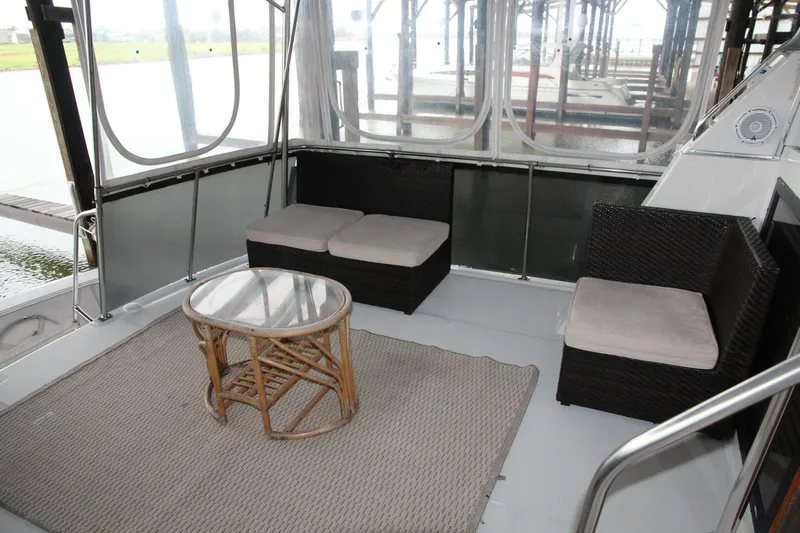 Aurora II Yacht Photos Pics 1989 Chris-Craft 480 Catalina yacht interior with wicker furniture and glass table.