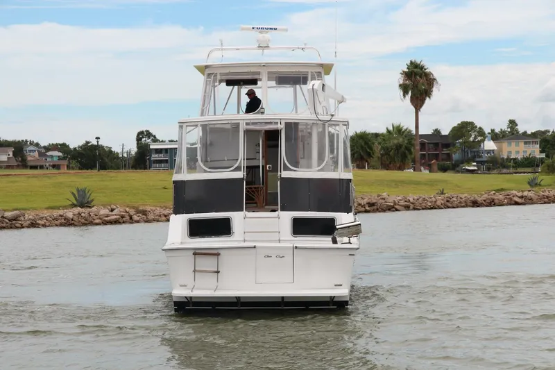 Aurora II Yacht Photos Pics 1989 Chris-Craft 480 Catalina yacht on calm water, with scenic background.