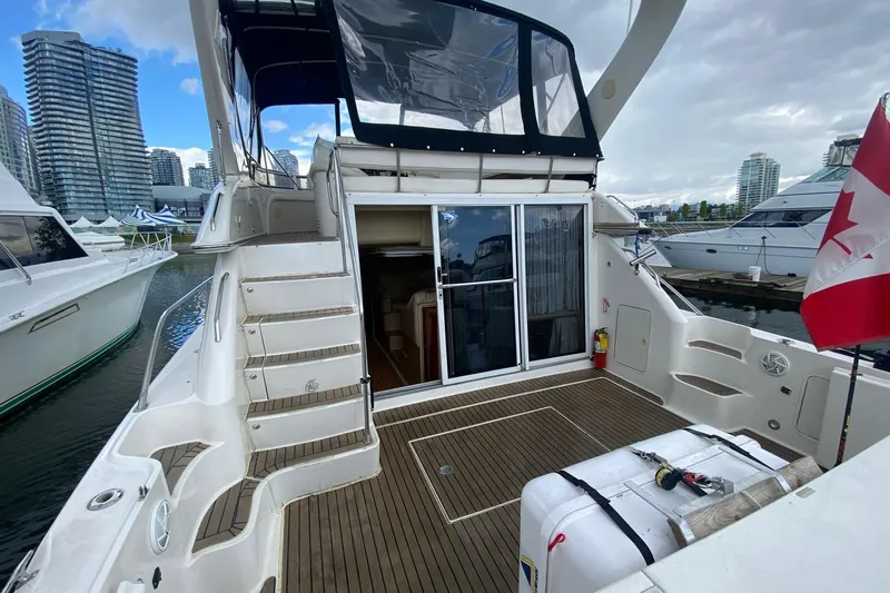 Oceanmax Yacht Photos Pics 2000 Sea Ray 450 Express Bridge yacht docked, featuring spacious deck and Canadian flag.