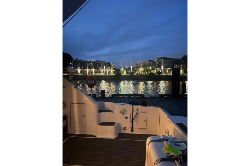 Oceanmax Yacht Photos Pics 2000 Sea Ray 450 Express Bridge at dusk, overlooking waterfront homes and reflections.