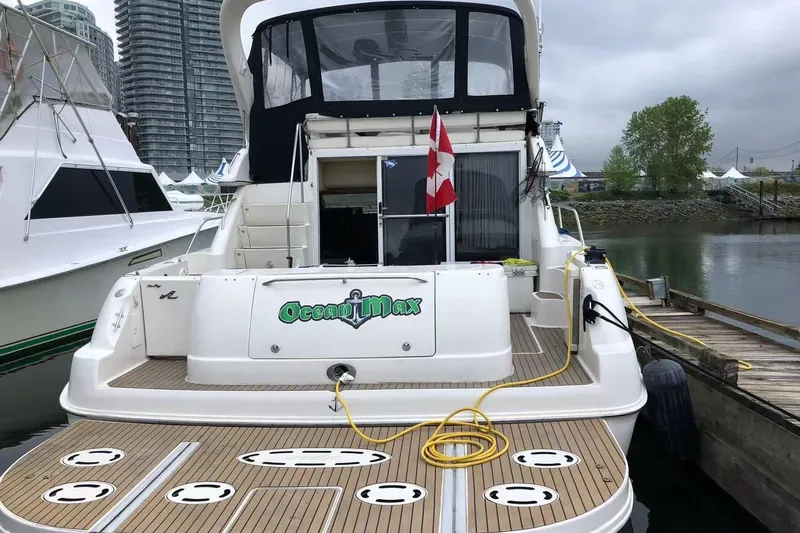 Oceanmax Yacht Photos Pics 2000 Sea Ray 450 Express Bridge docked, featuring spacious deck and Canadian flag.