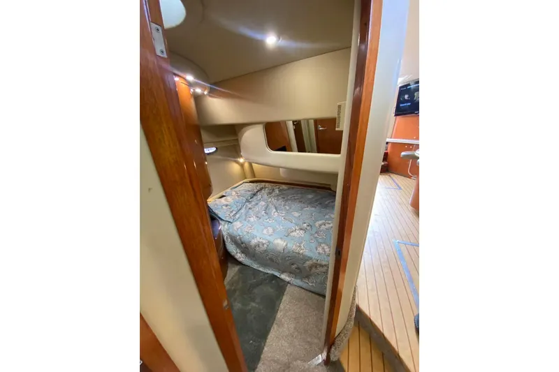 Oceanmax Yacht Photos Pics Interior cabin of 2000 Sea Ray 450 Express Bridge with cozy bed and wooden accents.