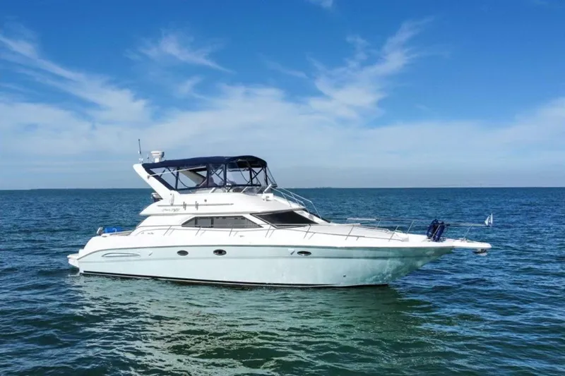 Oceanmax Yacht Photos Pics 2000 Sea Ray 450 Express Bridge yacht cruising on open water under clear skies.