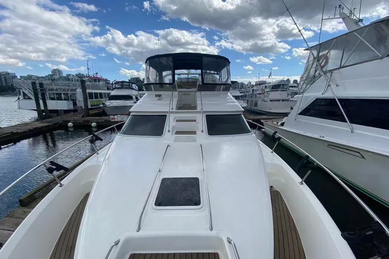 Oceanmax Yacht Photos Pics 2000 Sea Ray 450 Express Bridge yacht docked at marina under cloudy sky.