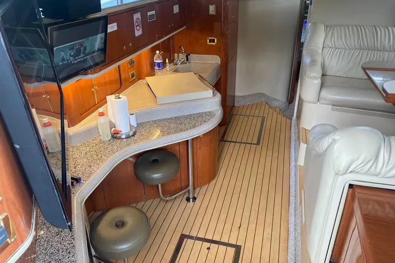 Oceanmax Yacht Photos Pics Interior of 2000 Sea Ray 450 Express Bridge with kitchen and seating area.