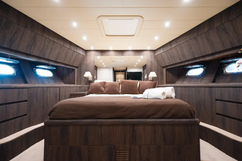 Yacht Photos Pics Luxurious bedroom interior of 2006 Arno Leopard 24 yacht with wood paneling and ambient lighting.