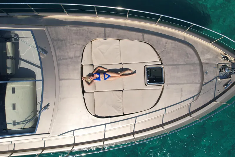  Yacht Photos Pics Woman sunbathing on Arno Leopard 24 yacht, 2006 model, in clear turquoise waters.