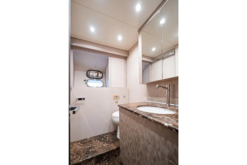  Yacht Photos Pics Luxurious yacht bathroom with marble countertop, modern fixtures, and porthole window in Arno Leopard 24.