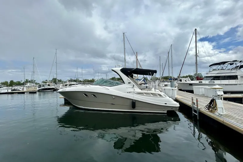  Yacht Photos Pics 2009 Sea Ray 310 Sundancer docked at marina under cloudy sky.