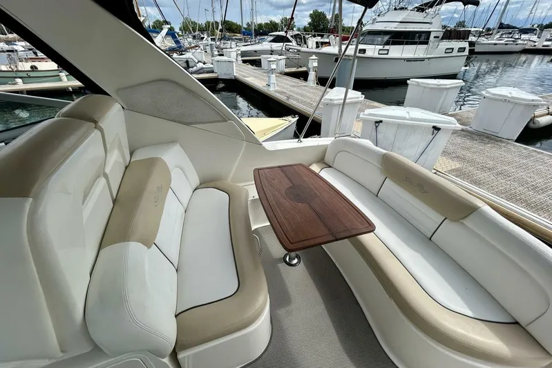  Yacht Photos Pics 2009 Sea Ray 310 Sundancer interior with beige seating and wooden table at marina.