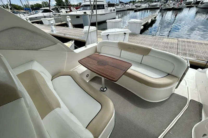  Yacht Photos Pics 2009 Sea Ray 310 Sundancer cockpit with seating and table, docked at marina.