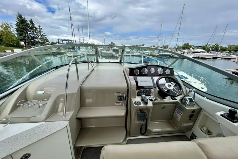 Yacht Photos Pics 2009 Sea Ray 310 Sundancer cockpit with steering wheel, controls, and marina view.