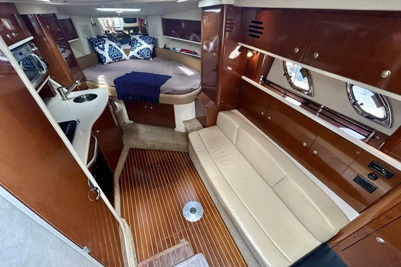  Yacht Photos Pics Luxurious interior of 2009 Sea Ray 310 Sundancer yacht with cozy seating and elegant wood finishes.