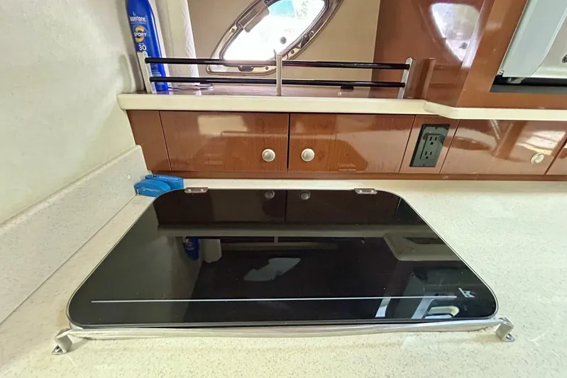  Yacht Photos Pics 2009 Sea Ray 310 Sundancer interior kitchen with stove and wooden cabinetry.