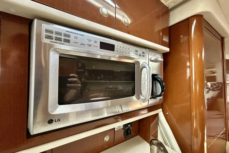  Yacht Photos Pics LG microwave in 2009 Sea Ray 310 Sundancer yacht kitchen, featuring wood cabinetry.