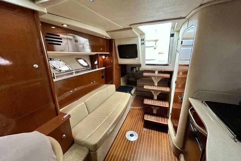  Yacht Photos Pics Luxurious interior of 2009 Sea Ray 310 Sundancer yacht with wooden finishes and comfortable seating.