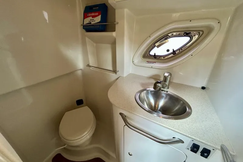  Yacht Photos Pics 2009 Sea Ray 310 Sundancer bathroom with sink, toilet, and porthole window.
