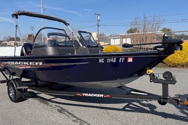 2023 Tracker Pro Guide V-16 WT boat on trailer, parked outdoors.