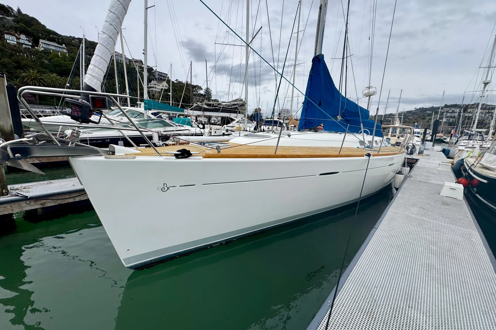 2003 Beneteau First 47.7 sailboat docked in a marina, featuring a sleek white hull.