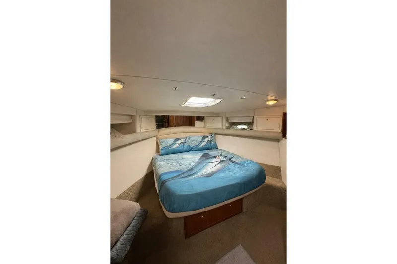 Fortuna Yacht Photos Pics Interior of 2002 Riviera 43 Open Flybridge with cozy bed and marine-themed bedding.