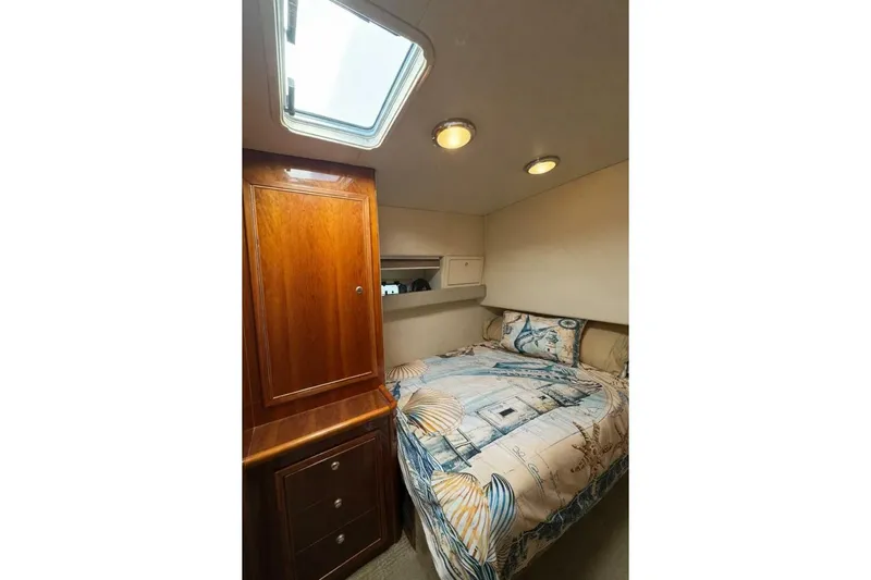 Fortuna Yacht Photos Pics Cozy bedroom in 2002 Riviera 43 Open Flybridge yacht with nautical-themed bedding.