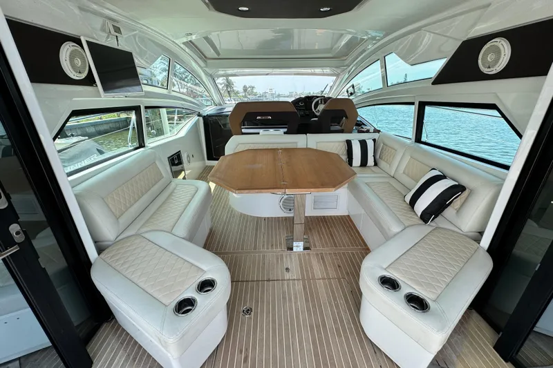  Yacht Photos Pics Luxurious interior of 2018 Beneteau Gran Turismo 46 yacht with elegant seating and wooden table.