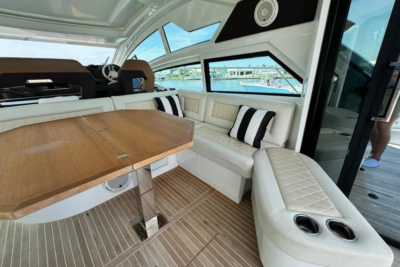  Yacht Photos Pics Luxurious interior of 2018 Beneteau Gran Turismo 46 yacht with elegant seating and wooden table.