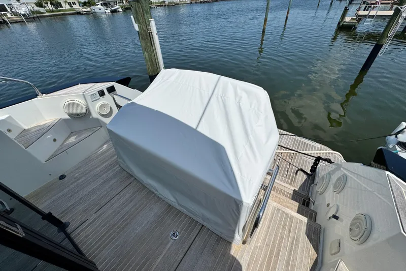  Yacht Photos Pics 2018 Beneteau Gran Turismo 46 yacht deck with covered equipment, docked by the water.