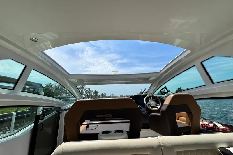  Yacht Photos Pics Interior view of 2018 Beneteau Gran Turismo 46 yacht with panoramic windows and steering wheel.