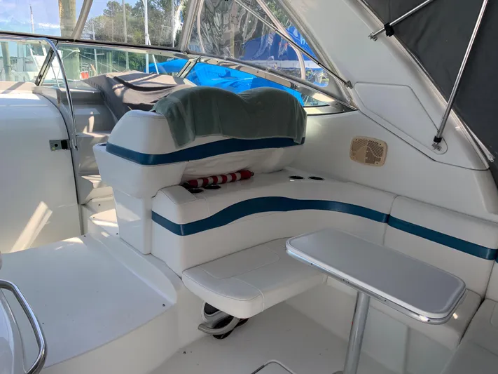  Yacht Photos Pics 2005 Formula 34 PC boat interior with white and blue seating and small table.