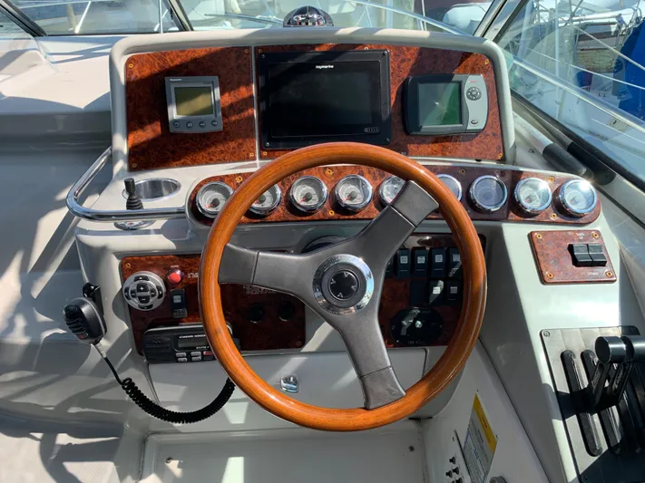  Yacht Photos Pics 2005 Formula 34 PC boat helm with wood-trimmed steering wheel and navigation instruments.
